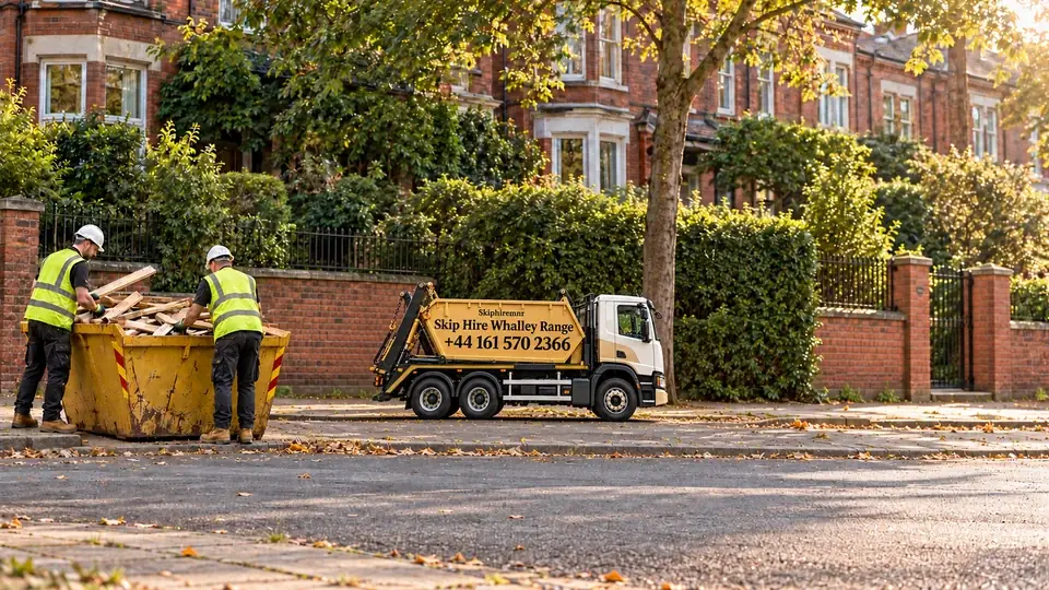 Illustrative Manchester Whalley Range scene with a gold and white truck branded Skip Hire Whalley Range, +44 161 570 2366, and workers loading a lowered skip.
